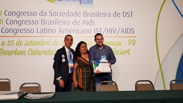 #PraCegoVer: Na imagem, representantes do DST/AIDS em pé recebendo premio.